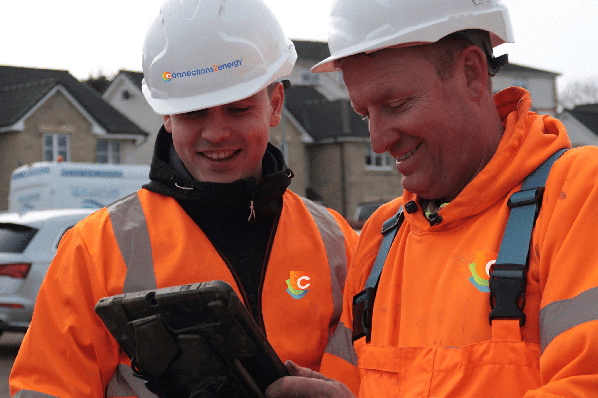 men in orange hi vis discussing a temp supply