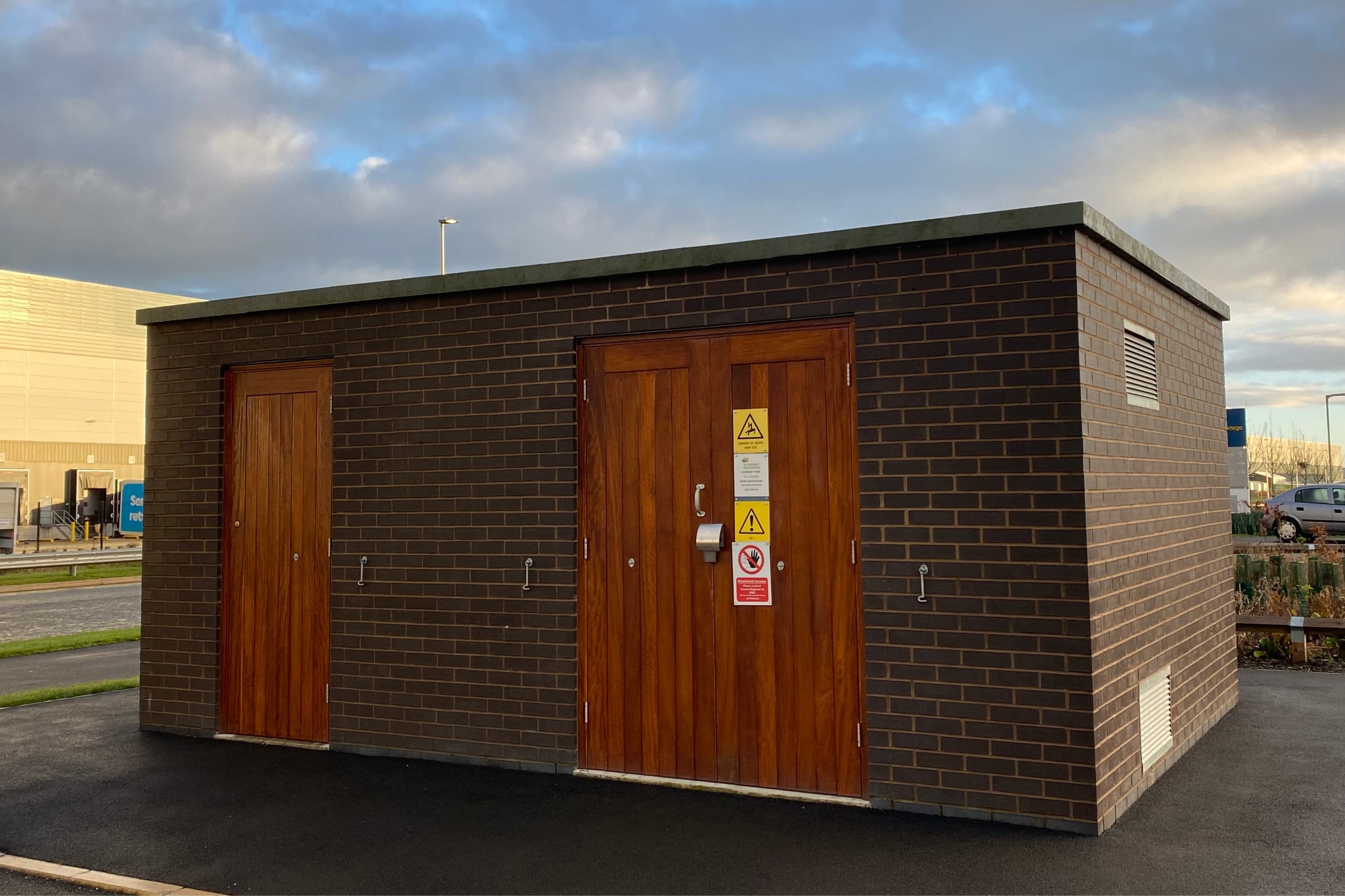 Brick wall electric substation with wooden doors connections2energy