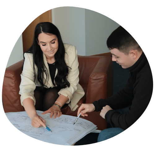 a woman and a man looking at blue print plans for an electric connection