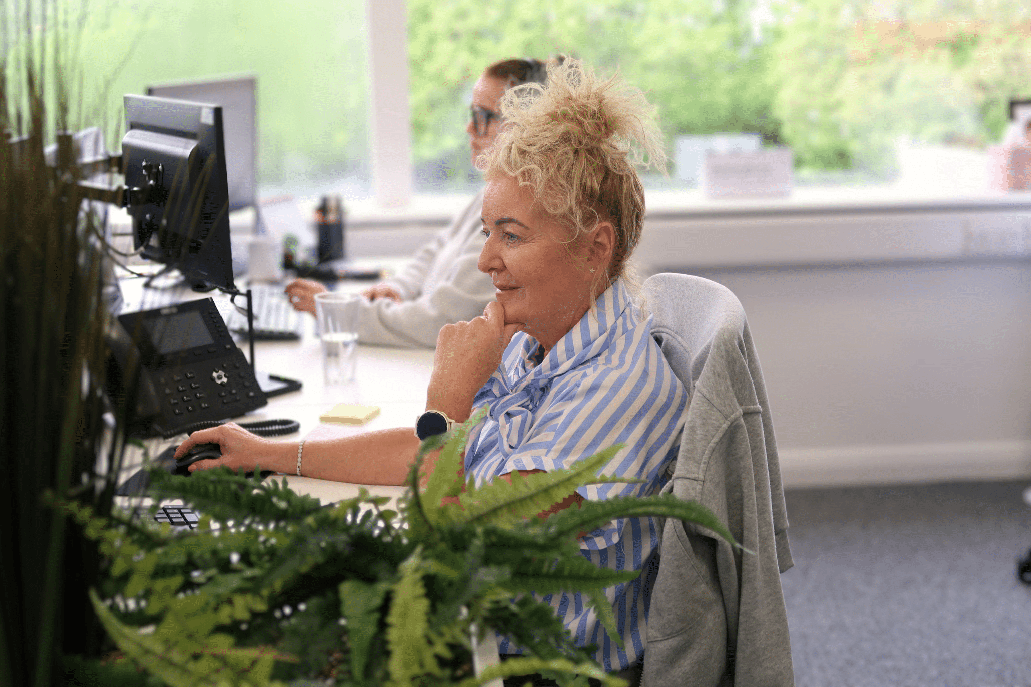 Alt Text: Connections2energy team member working at their desk in the office, managing utility connection projects for clients across the UK