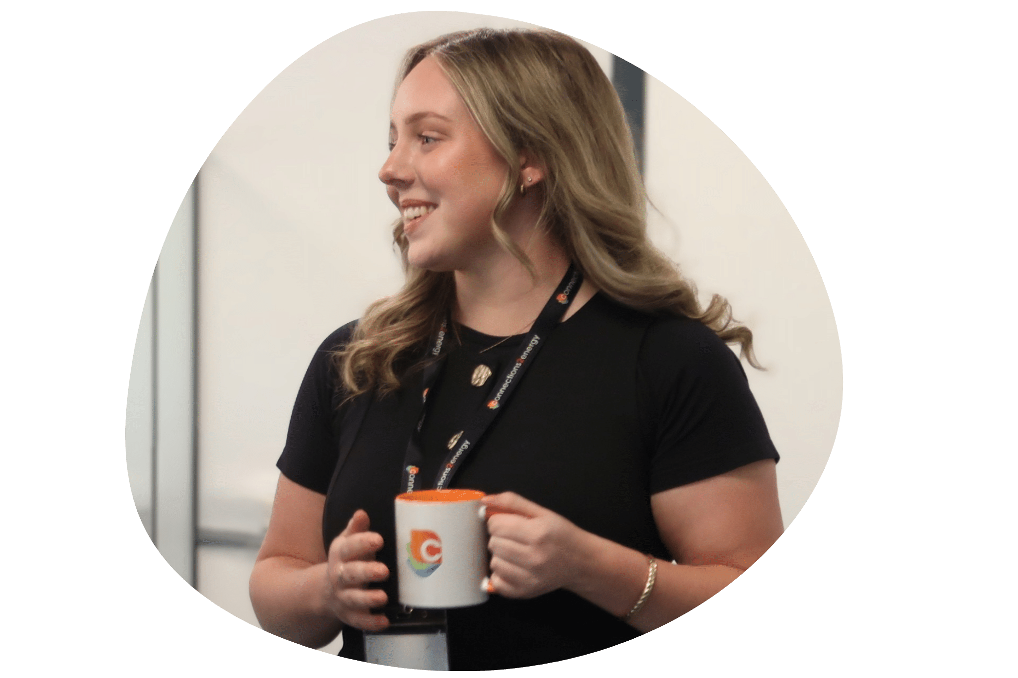 Connections2energy team member smiling during a project meeting, holding a branded mug